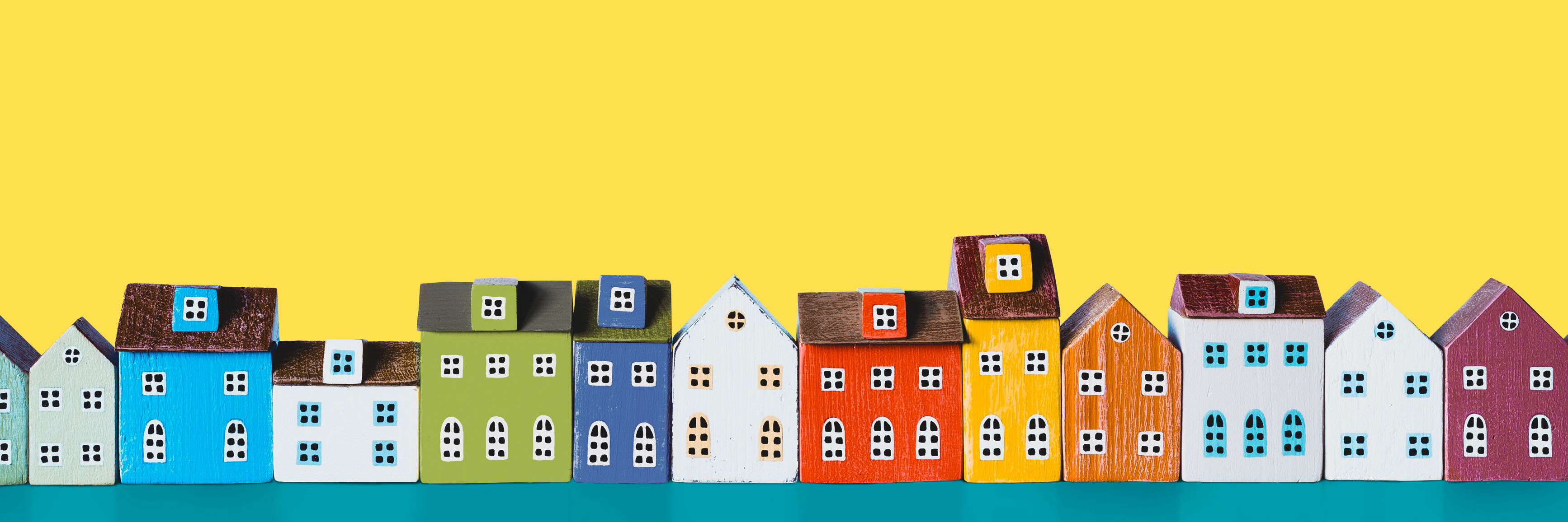 En masse figurer af huse står på en lang række. Husene har mange forskellige farver.