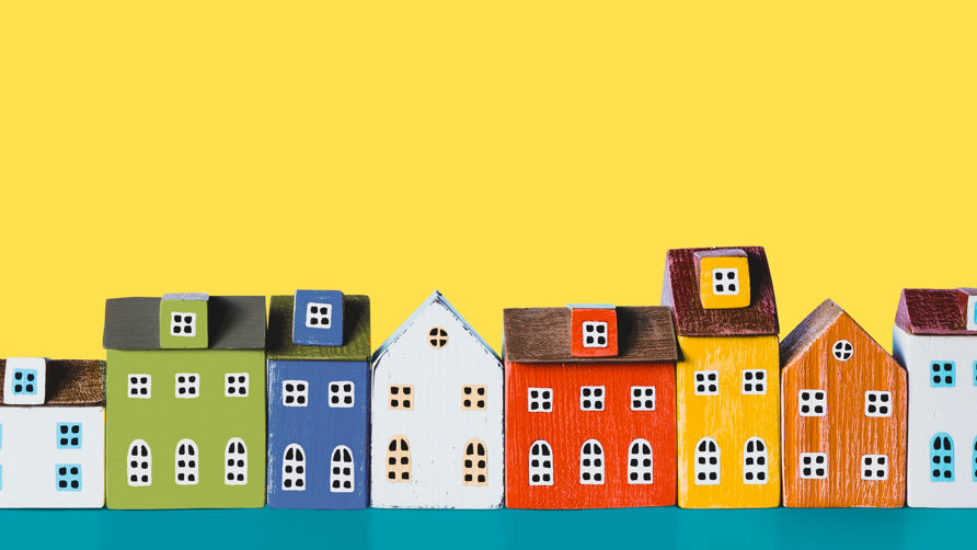 En masse figurer af huse står på en lang række. Husene har mange forskellige farver.